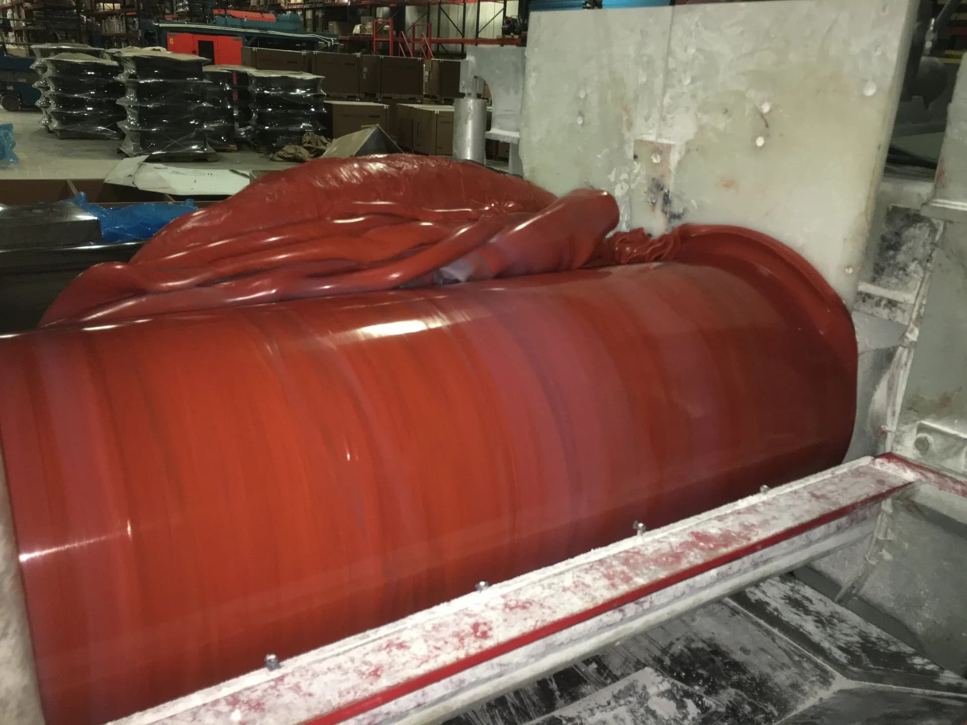 Red silicone compound being worked on a mill