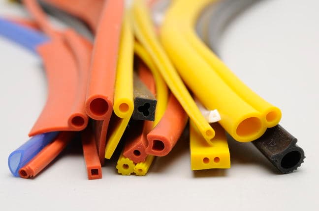 Bundle of extruded tubing in orange, yellow and black, cut ends showing the bores