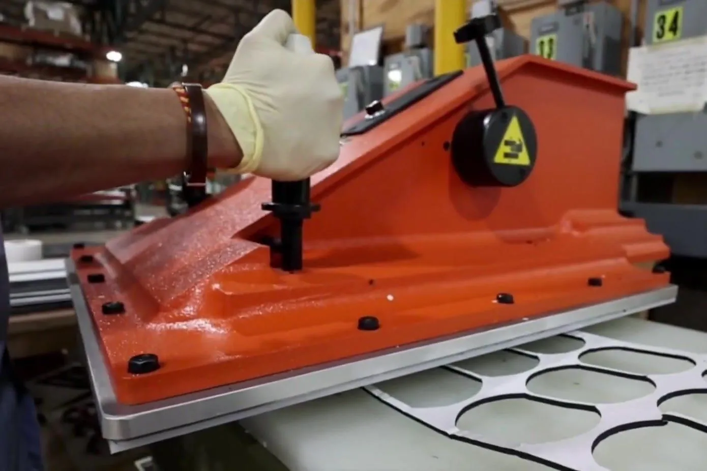 Operator cutting rubber parts on a die-cutting press