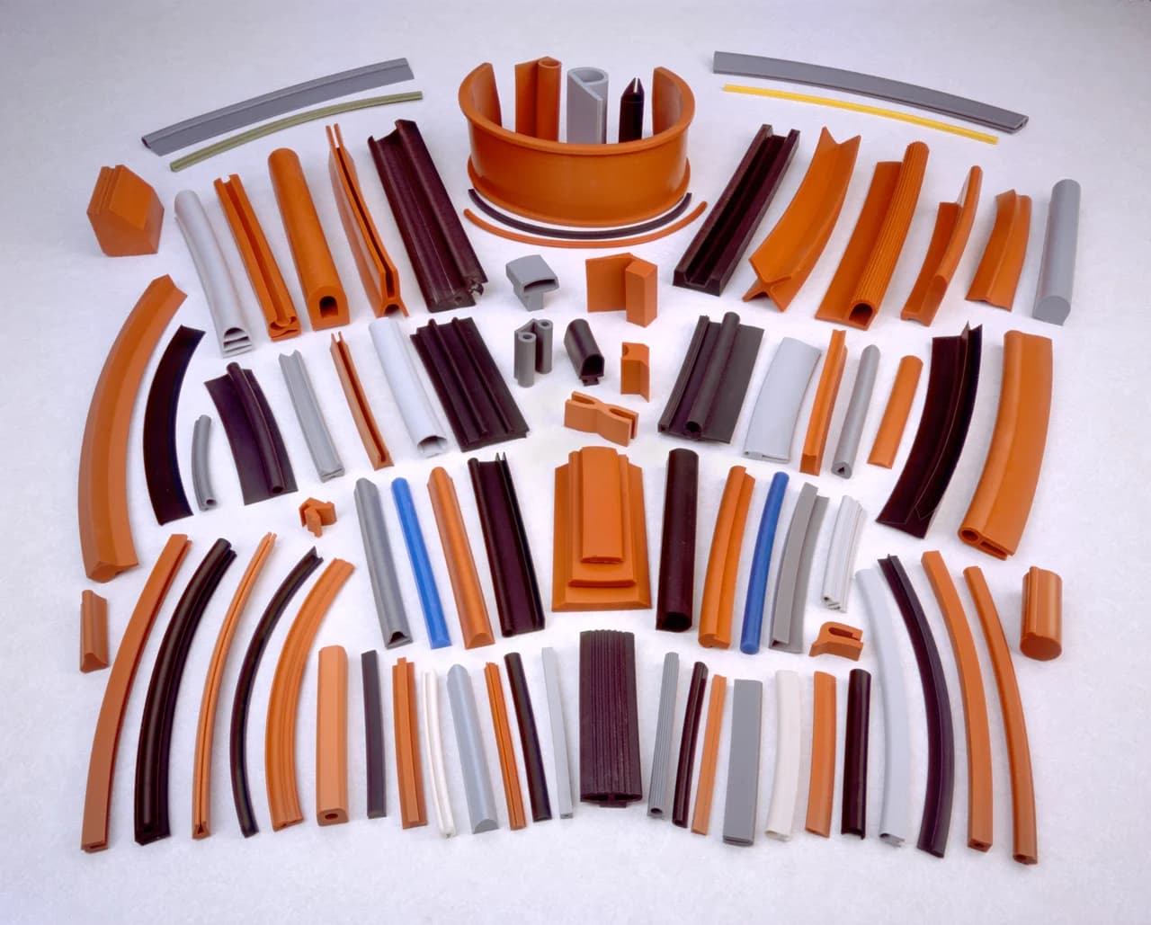 Assorted custom extruded rubber profiles laid out on a white surface